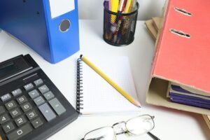 Desk with reports, binders, and a notebook, representing a roundup of B2B outsourcing case studies, by IDEAIFY Solutions