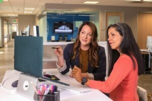 Two B2B sales professionals reviewing a LinkedIn outreach campaign on a laptop, by IDEAIFY Solutions