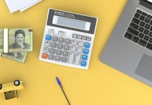 Calculator next to a laptop on a desk, representing 2027 outsourcing ROI and budget planning, by IDEAIFY Solutions