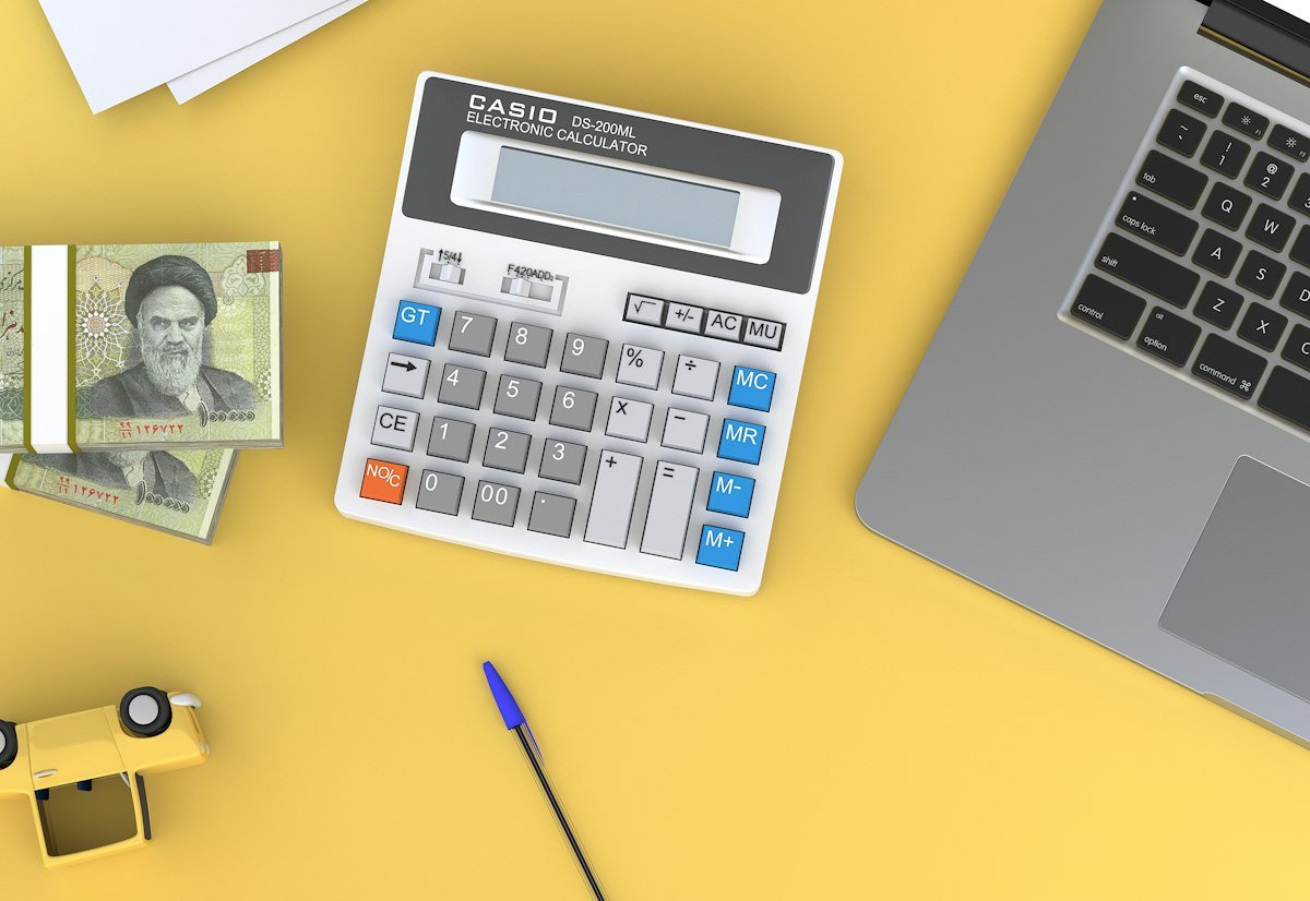 Calculator next to a laptop on a desk, representing 2027 outsourcing ROI and budget planning, by IDEAIFY Solutions
